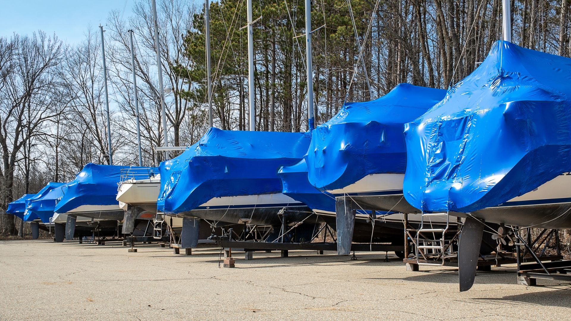 boats in storage with blue shrink wrap